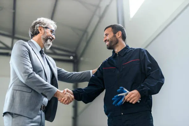 A customer shaking hands with a technician in the shop
