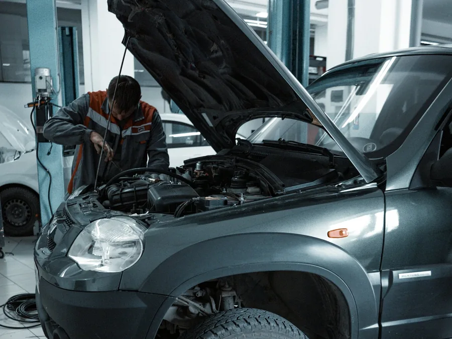 A technician working in an engine bay in the shop